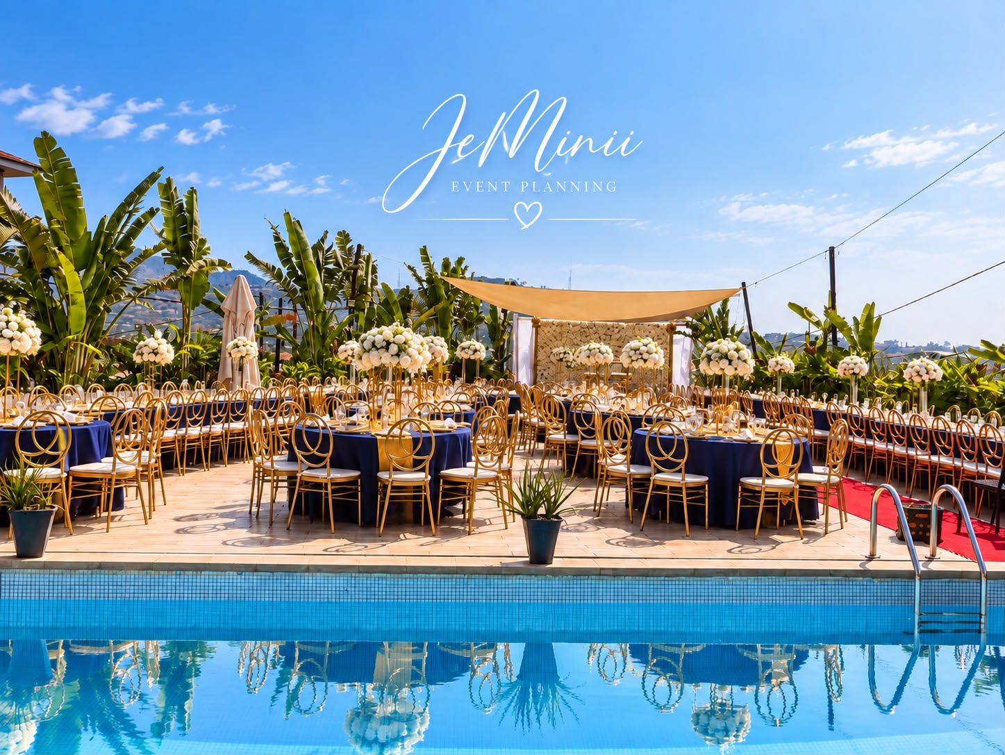 Outdoor wedding reception beside a pool with navy tables, gold chairs and white floral centrepieces, styled by Jeminii Event Styling in Freetown, Sierra Leone